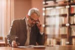 Senior businessman thinking while going through paperwork in the office.